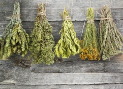 Variety of dried herbs and spices on an old wooden background