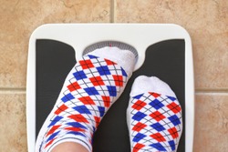 Woman's feet on bathroom scale. Diet concept