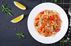 Pasta spaghetti with shrimps, tomato and parsley. Healthy meal. Italian food. Top view. Flat lay