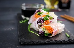 Vegetarian vietnamese spring rolls with spicy sauce, carrot, cucumber, red cabbage and rice noodle. Vegan food. Tasty meal.  Copy space