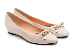 Pair of beige female shoes over white background