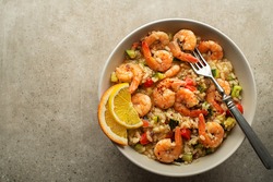 Healthy risotto meal with grilled shrimps and vegetables on grey background. Grilled prawns. Healthy food. Seafood.