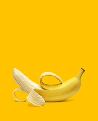 Peeled banana on yellow background with copy space