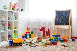 Children's playroom with plastic colorful educational blocks toys. Games floor for preschoolers kindergarten. interior children's room. Free space. background mock up chalkboard