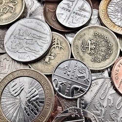 Close up of British Coins including bronze and silver, pound coins, pence and pennies. Creative filters and textures have been applied for effect