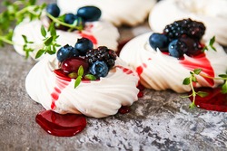 Meringue dessert Pavlova cake with fresh berries on a stone background