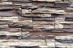 Wall stonework finishing from colorful natural stone trim as background front view close up