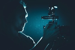 Filmmaker with Modern DSLR Video Camera Taking Shot in a Dark. Making Documentary Film. Professional Videography Equipment.