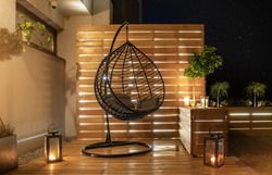 Garden Furniture Design. Starry Night Time in Stylish Backyard Garden with Wooden Porch with Wall and Planters Illuminated by Modern LED Lighting.