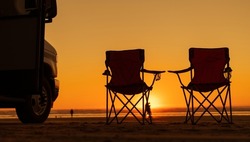 Scenic Beach Sunset Vista with RV Motorhome and Two Camping Chairs. California Coast, United States of America.