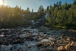 Scenic Norwegian Wilderness River with Rocky Bed. Scandinavian Summer Sunset Scenery. Norway, Europe.