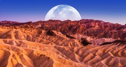 Death Valley Scenic Night. Death Valley National Park Badlands Sandstones Landscape and the Moon. California, United States.
