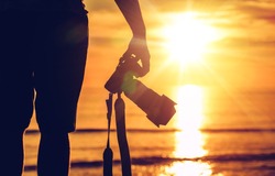 Sunset Photography. Photographer Ready to Take Sunset Pictures on the Beach. Professional Travel Photography Works.