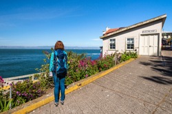 Young woman is admiring the view from Alcatraz island in San Francisco Bay, United States of America