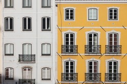 Traditional row houses with white and yellow facades in Lisbon, Portugal.
