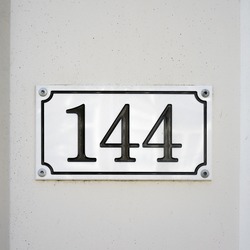 house number one hundred and forty four, engraved in a plastic plate