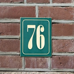 House number seventy six engraved in a plastic plate.