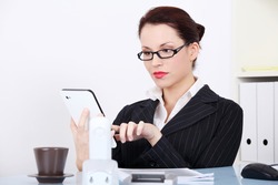 Pretty caucasian businesswoman using a tablet in the office.