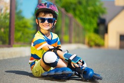 Cute little boy in sunglasses and helmet with rollers