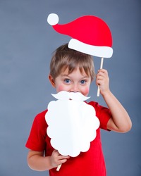 Christmas concept. Smiling funny boy in Santa red hat in studio.