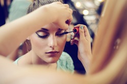 Make-up artist applying the mascara to model. Close up. 
