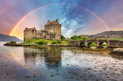 Eilean Donan Castle with rainbow and reflection in water, Scotland.