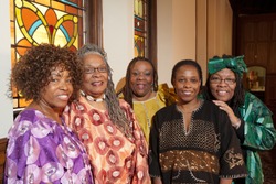 Location shot of colorfully dressed older African women dressed in colorful outfits in a church. 