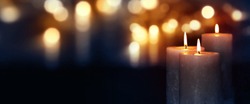 Dark blue background with burning candles and golden bokeh for a solemn occasion