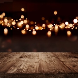 Festive dark background with golden light effects and empty wooden table for a christmas decoration