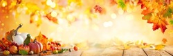 Autumn banner with fallen maple leaves and pumpkins on wooden vintage table. Autumn concept with red-yellow leaves background. Thanksgiving pumpkins.