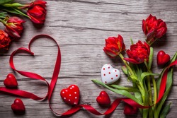 Valentines Day background with chocolates, hearts and red tulips