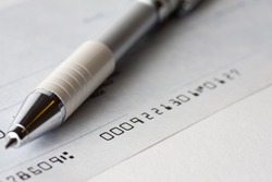 Close up shot of a cheque or cheque with a pen