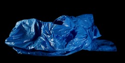 Blue clean, crumpled plastic garbage bag isolated on black background
