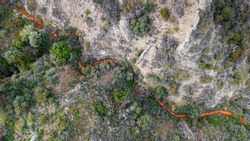 Aerial view of acid drainage from an abandoned copper mine in Kalavasos area, Cyprus. Odd red color of the stream derives from high levels of sulfuric acid and heavy metals