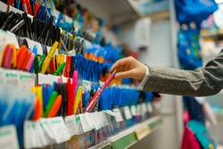 School girl choosing a pen in stationery store