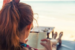 Young woman reading a book at beach