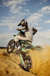 Extreme motocross rider riding on dirt track