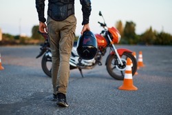 Male person holds helmet, motorcycle school