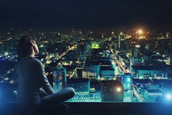 Pensive woman is looking at night city
