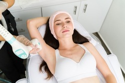 Top view of a caucasian woman with smooth skin at the beauty parlor receiving a radio frequency procedure 
