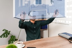 Architect looking at a simulation. Latin young man using a VR headset and joystick while making a virtual tour through a real estate