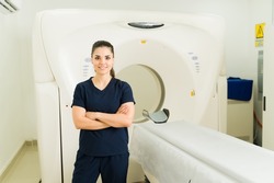 Female radiologist smiling while waiting for a patient for medical test or cat scan at the imaging laboratory