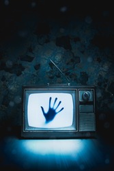 High contrast image of an old vintage TV with a hand inside