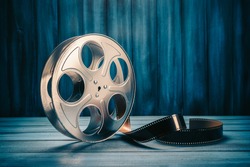 35 mm film reel with dramatic lighting on a wooden background