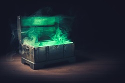 open pandora's box with green smoke on a wooden background /high contrast image
