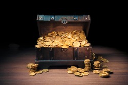 Open treasure chest filled with gold coins / HIgh contrast image