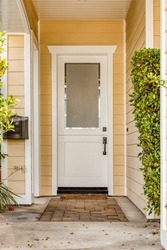 White front door and yellow painted home exterior