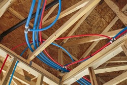 New Home Construction with PEX Plumbing pipes and exposed beams.