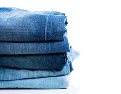 stack of blue jeans closeup with white background