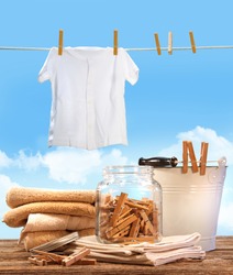 Laundry day with towels, clothespins on table against blue sky